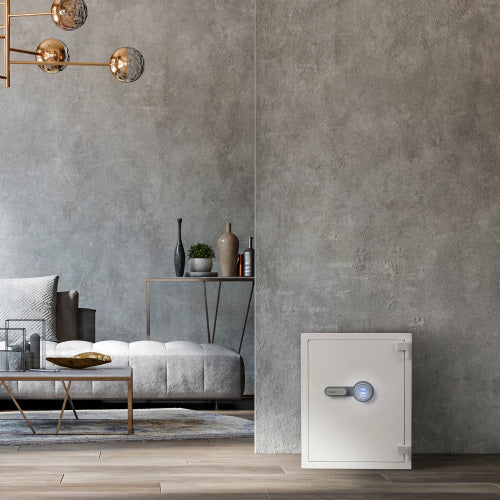 GLACIER XL Biometric fireproof safe, standing in a bedroom corner beside a bench and shelving