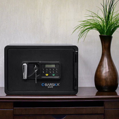 BASALT XS keypad fireproof safe box, closed on a wooden sideboard beside a vase