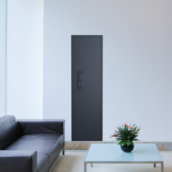SLATE Biometric wall gun safe in black, installed flush in a living room wall behind a sofa