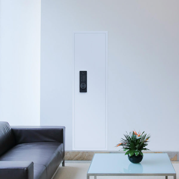 SLATE Biometric wall gun safe in white, installed flush in a living room wall behind a sofa
