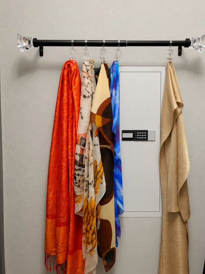 SLATE M in-wall gun safe in white, partly hidden behind scarves on a wall rail