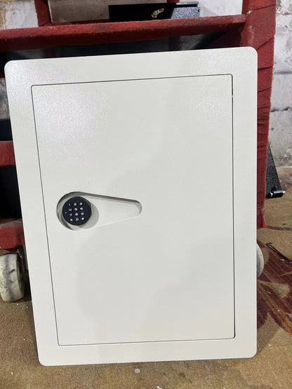SLATE S in-wall safe in white, photographed installed in a stud wall opening before finishing
